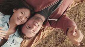 VERTICAL VIDEO: Young couple lying on blanket in the park from outside - Powered by Shutterstock - Get 15% off with code: PIKWIZARD15
