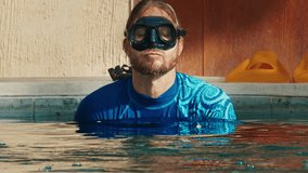 Set of clips about male freediver. Male freediver dives in the pool, swims in the pool, appears from water, portrait.
