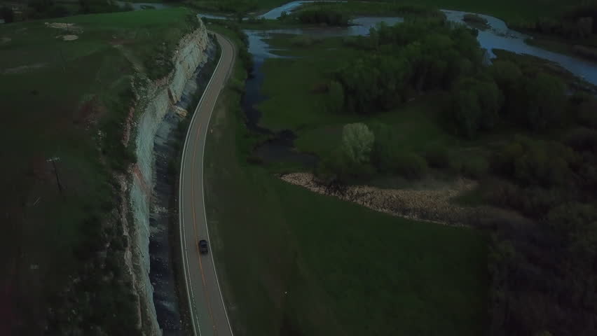 Aerial Tilt Up Shot Of Pickup Truck Moving On Road Passing By Mountain Against Sky - Billings, Montana