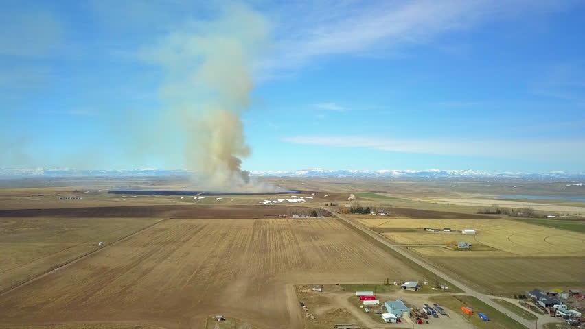 Aerial Forward Shot Of Smoke Emitting From Field Against Sky On Sunny Day, Drone Flying Forward Over Landscape - Billings, Montana