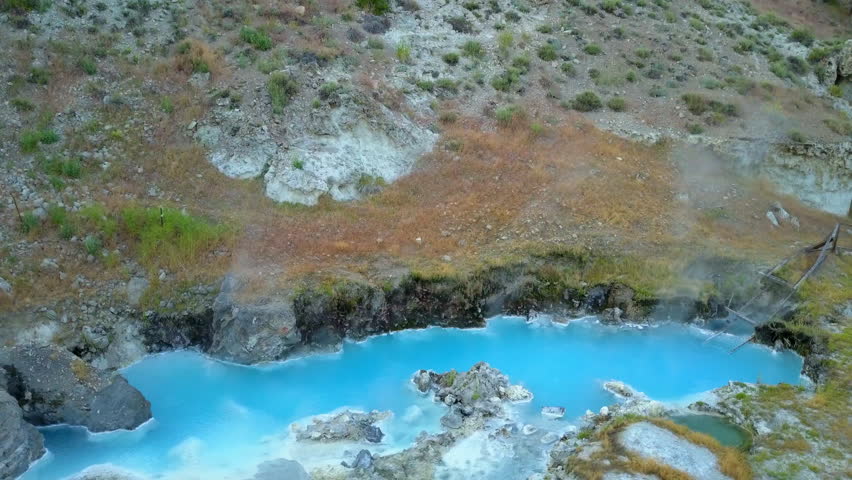 Aerial: Tilt Down Shot Of Boiling Lake Near Plants At Sunset, Drone Ascending Over Hot Spring - Mammoth Lakes, California