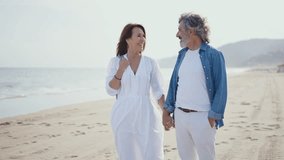 Cinematic video of a senior couple spending time on the beach and making different activities near the ocean. Romantic concept about a man and a woman in love. Lifestyle in the seniority age