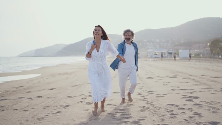 Cinematic video of a senior couple spending time on the beach and making different activities near the ocean. Romantic concept about a man and a woman in love. Lifestyle in the seniority age Royalty-Free Stock Footage #1106326479