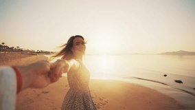 Happy woman holding man hand looking at him running to ocean at sunset on sandy beach. Follow me gesture. Loving couple having romantic date enjoying walking along sea shore. Travel, tourism concept. - Powered by Shutterstock - Get 15% off with code: PIKWIZARD15