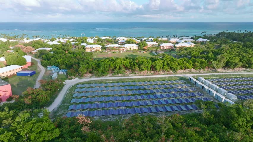 Solar panels with sea in background powering hotels of Punta Cana, Dominican Republic. Aerial sideways