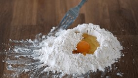 Person mixing with fork an egg with wheat flour on table to make homemade food. Close up - Powered by Shutterstock - Get 15% off with code: PIKWIZARD15