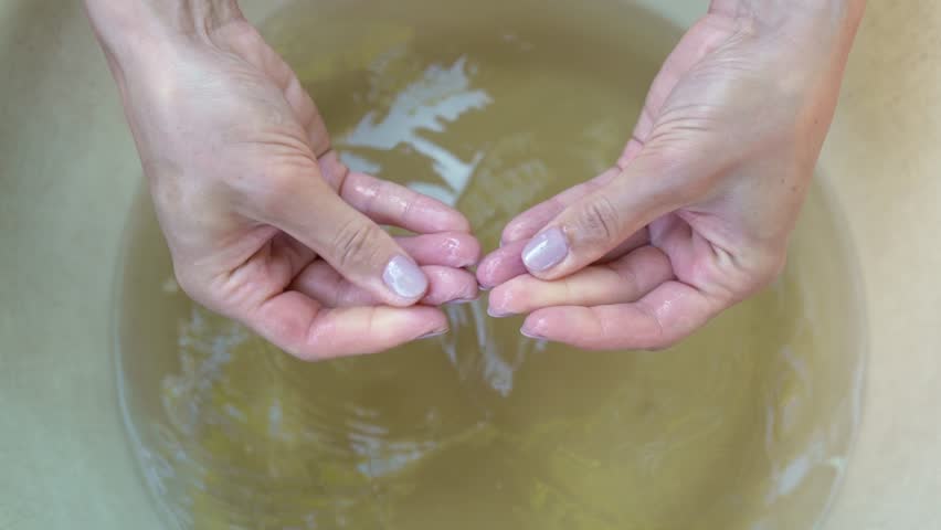 Demonstration female hands with wrinkles after bath. Woman showing her palms after long hand washing in the basin. Wrinkled or pruney skin on fingers because of soak in the water for a long time in 4K Royalty-Free Stock Footage #1106336667
