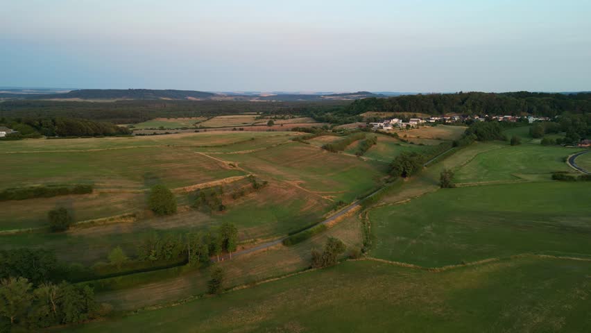 	Aerial view of crop fields scorched by the summer heat, shot at sunset in rural Luxembourg.