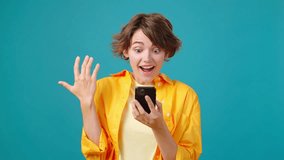 Young woman looks at mobile phone and exclaims in surprise. Happy user points finger to screen recommending website or app against turquoise wall - Powered by Shutterstock - Get 15% off with code: PIKWIZARD15