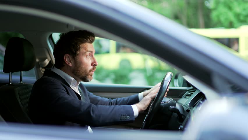 Furious angry man standing in a traffic jam beeps and hurries. Sitting in the car. Irritated nervous mature adult business male in suit tired driver in automobile. Stressful commuting to be late work Royalty-Free Stock Footage #1106340543