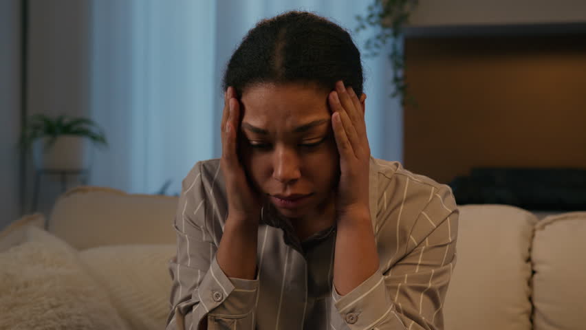 Sorrowful upset African American woman stressed girl suffer headache grief sorrow depression crying lady at night evening home close face with hands worried mental problem breakup unwanted pregnancy Royalty-Free Stock Footage #1106348247