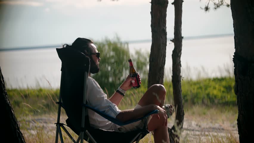 Weekend Chill Drinking Beer. Cool Refreshment At Serene Atmosphere. Pale Ale Beer Lover Chilled Beverages Tranquil Retreat. Sunset Sip Wheat Beer From Bottle. Calm Blissful Moment Sunset Reflection Royalty-Free Stock Footage #1106353125