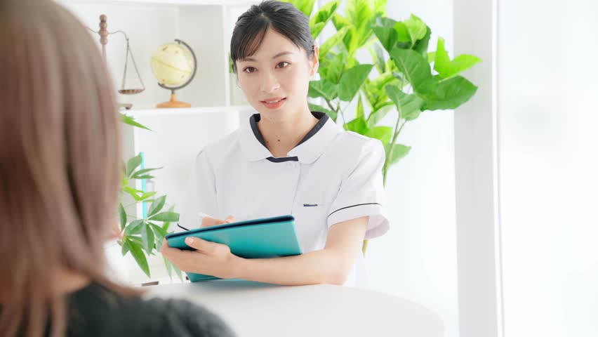 Female medical worker interviewing a patient in medical facility. Nursing. Therapist. Royalty-Free Stock Footage #1106357125