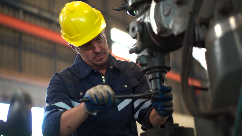 Senior professional mechanical engineer or technician working in the heavy metal work machine in a factory.  Technician repairing and doing a maintenance on machine. Royalty-Free Stock Footage #1106358199