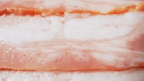 Macro video captures the raw beauty of bacon. The probe lens delves deep, revealing its marbled fat, savory texture. Prepare for an immersive bacon experience like never before. Bacon background
