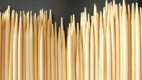 Macro video shot with a probe lens captures the intricate details of a toothpick's texture, revealing its wood grain, delicate fibers, and sharp point, showcasing the beauty. Wood background. 4K UHD
