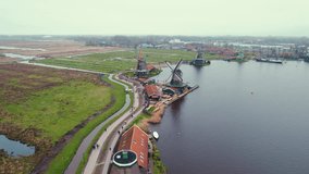 Video shot of beautiful Dutch windmills by the river with a city in the background. High quality 4k footage