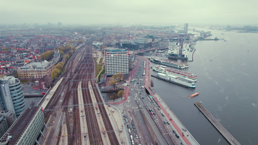 Amsterdam Centraal Central Railway Station, cruise boats on the river IJ - cityscape from above. High quality 4k footage