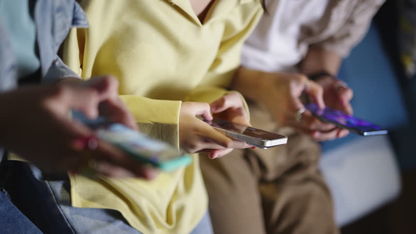 Hands of people chatting on social networks. Close-up hands of people scrolling feed in social networks, chatting texting in messengers, surfing social media, checking news, playing mobile games.