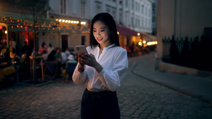 Incredibly beautiful Asian woman using an augmented reality phone to browse web pages, apps, and social networks. Wireless communication network concept. global digital network Royalty-Free Stock Footage #1106370087