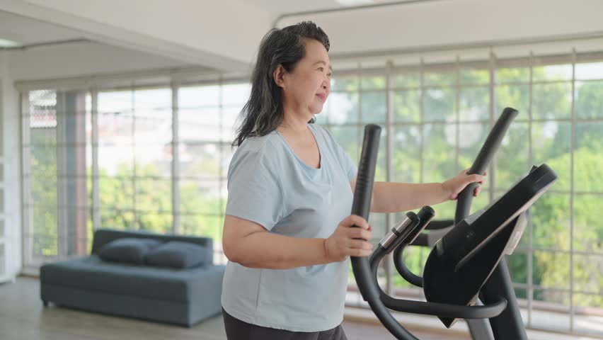 Happy asian senior women exercise on the machine in living room. Elderly women enjoy working out at home. Elderly lifestyle, Wellbeing concept Royalty-Free Stock Footage #1106370673
