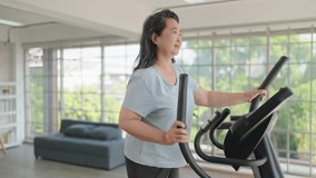 Happy asian senior women exercise on the machine in living room. Elderly women enjoy working out at home. Elderly lifestyle, Wellbeing concept - Powered by Shutterstock - Get 15% off with code: PIKWIZARD15
