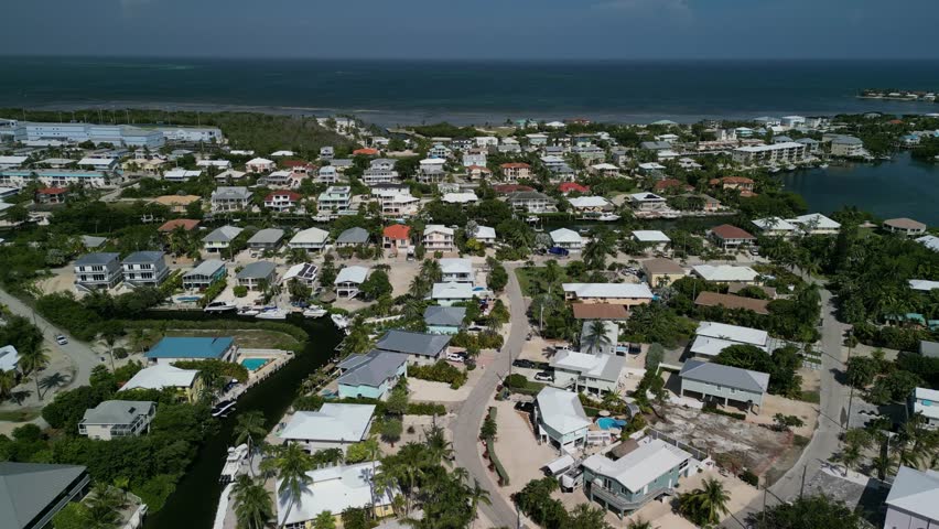 Aerial view of flying over luxury real estate in the Florida Keys towards the ocean