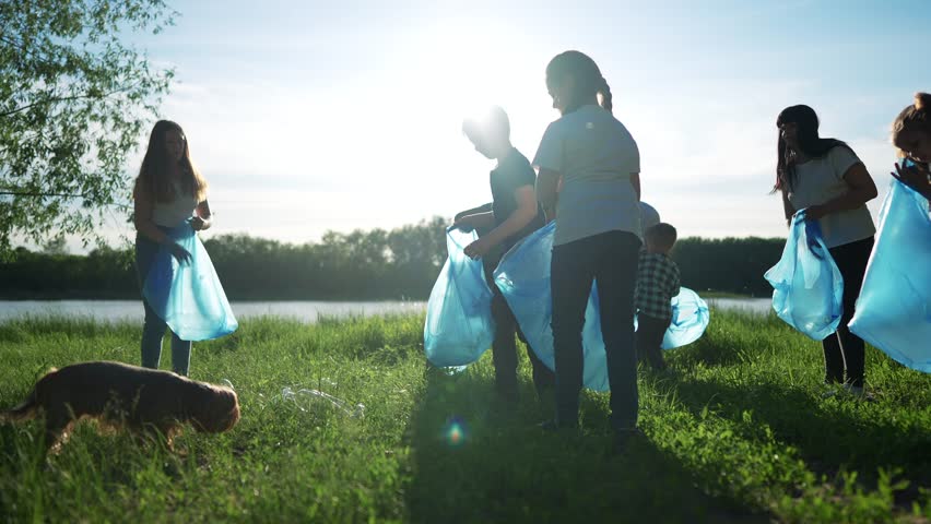 group of volunteers clean up trash. environmental protection ecology cleaning from garbage plastic concept. group people volunteers collects plastic world bottles garbage in bags silhouette Royalty-Free Stock Footage #1106381703