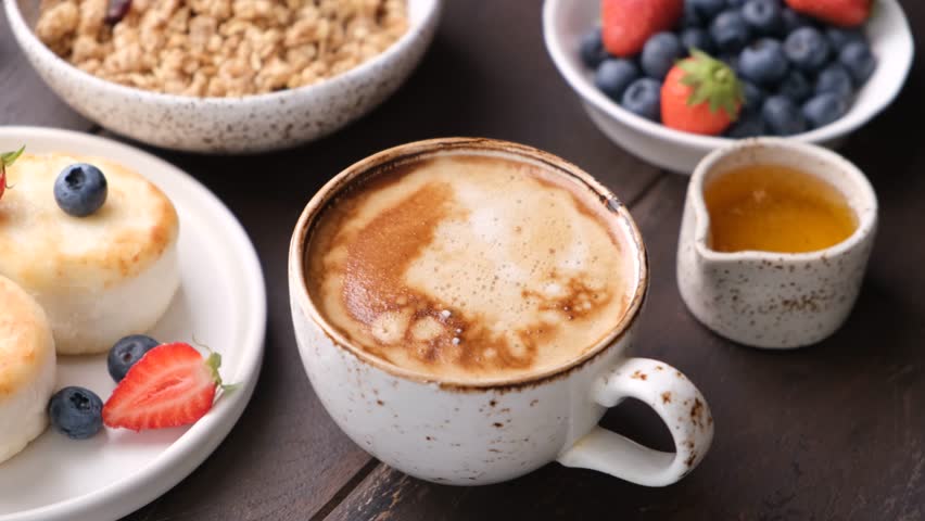 Breakfast coffee Cappuccino, mini cheesecakes Syrniki with berries and granola bowl | Shutterstock HD Video #1106384875