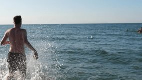 Young man runs into the sea to swim - Powered by Shutterstock - Get 15% off with code: PIKWIZARD15