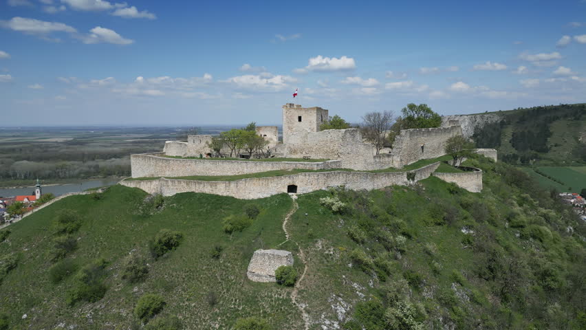 Aerial around view of ruined castle on hill, city Hainburg an der Donau and Danube river in Austria, 4k