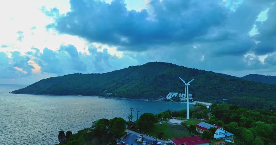 aerial view Wind turbine blades spinning on top of a mountain
Wind power generates electricity. Clean energy from nature.
Landmark Windmill Viewpoint close to Promthep cape.
sea and sky background.
