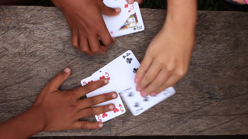 Multiethnic group of children and adults bonding and having fun playing card game together, top down view of hands holding cards, friendship or diversity concept Royalty-Free Stock Footage #1106389379