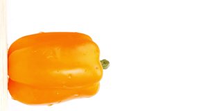 4K footage vertical video Front view CU, Fresh yellow bell peppers from the carousel farm on a white background.