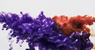 Slow motion video of purple and orange watercolor ink mixed in water against grey background. Beautiful abstract background concept