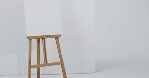 Video of white canvas sign on wooden easel with copy space on white background. Signage and writing space concept.