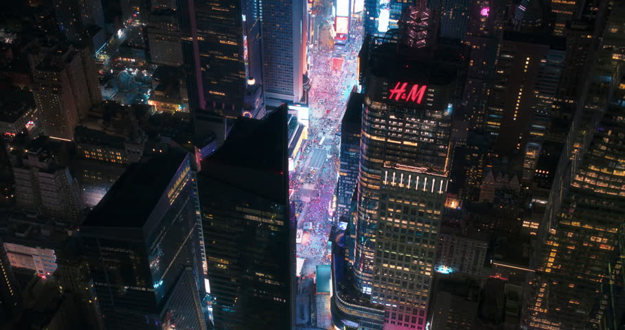 May 2023 Helicopter Night Tour of New York City Architecture. Fly-By Over Glowing Times Square with Groups of Tourists Enjoying Manhattan Nightlife and Admiring the Landmark with Diverse Advertising Billboards