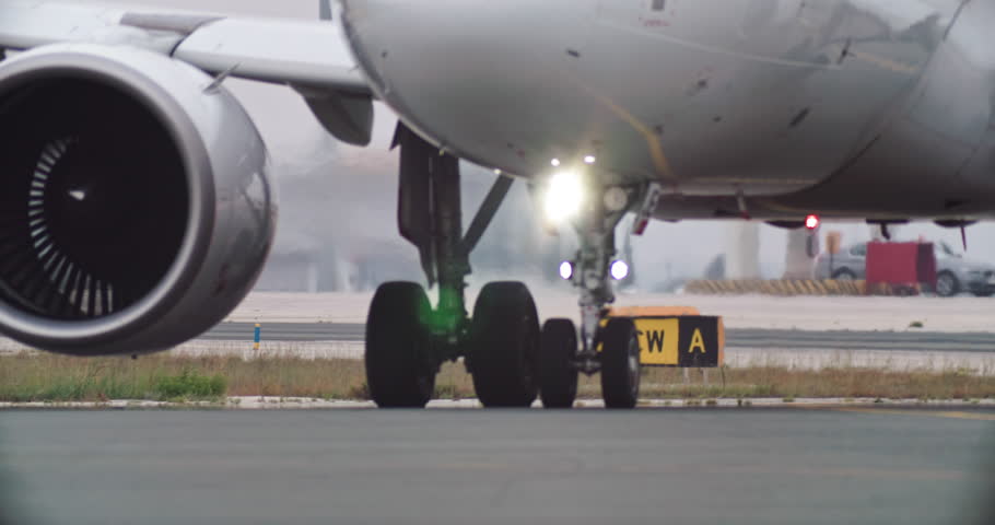 The wheels of a passenger plane drive down the airport runway after landing. Aviation and airplane flights. High quality 4k footage Royalty-Free Stock Footage #1106402381