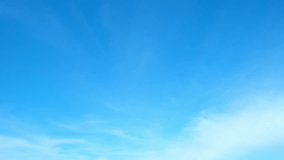 Timelapse footage captures the serene beauty of a vibrant blue sky adorned with fluffy white clouds, as they gracefully dance across the expansive horizon. Time-lapse. Sky background. Nature concept
