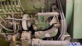 Engine belt drive rotates the pulley of emergency diesel generator. Machine running. V-belt on the dirty generator diesel engine - Close up shot