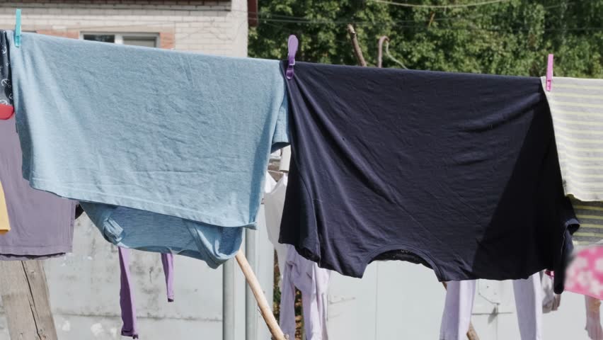 Various clothes are drying on the laundry line against the backdrop of the village.