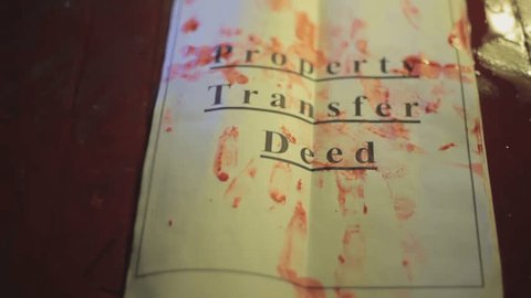 Top view of papers of "Property Transfer Deed" lying on the ground with blood on it and placing gun. Hd footage of property papers on the floor.
 Adlı Stok Video