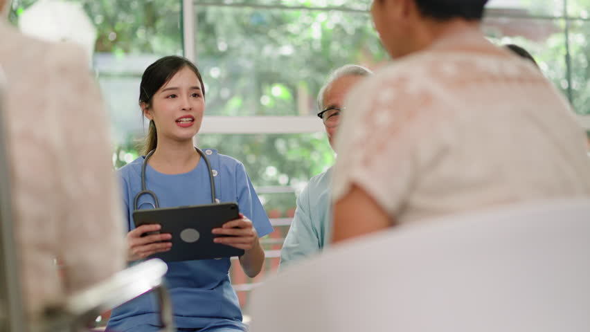 Group of asian senior people listening to young nurse.Psychological support group for elderly therapy session in a community centre. Group therapy in session sitting in a circle in a nursing home. Royalty-Free Stock Footage #1106414177
