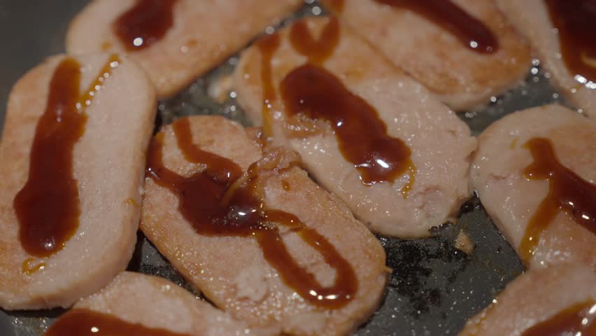 This close up video shows slices of luncheon meat frying on a pan for masubi. Royalty-Free Stock Footage #1106415591
