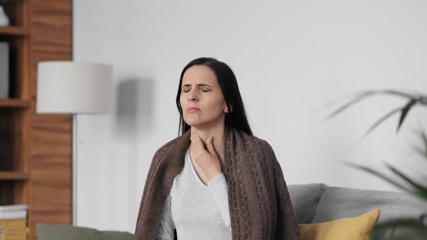 Portrait of ill young woman at home having cough and sore throat. First symptoms of cold and flu virus, pneumonia, bronchitis and respiratory tract infection. Seasonal virus disease. Royalty-Free Stock Footage #1106416509