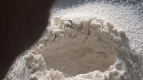 a raw egg is broken into a pile of flour, it slowly falls, the ingredients for baking are close-up, the cooking process in the home kitchen - Powered by Shutterstock - Get 15% off with code: PIKWIZARD15