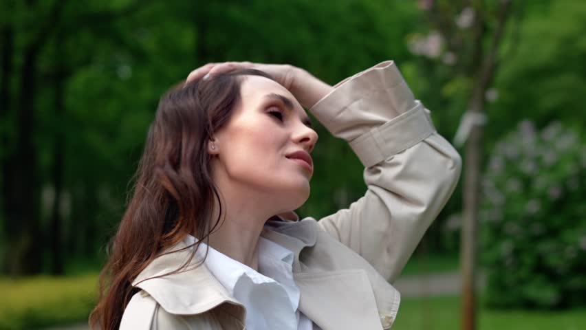 Portrait of beautiful woman that walk in city park. Smiling woman looking around with love. Girl going home after work or date and are happy