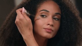 Close up female mirror reflection African American beautiful woman girl with perfect skin make-up apply oil face serum skincare product liquid cosmetic under eyes anti-aging wrinkle moisture formula - Powered by Shutterstock - Get 15% off with code: PIKWIZARD15