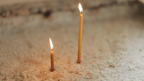 two burning candles for baptism in the orthodox church. Christian faith and traditions. Two burning candles in an orthodox church, close up. horizontal orientation video