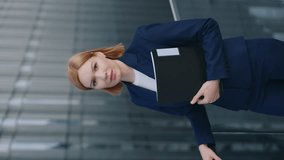 Vertical shot portrait attractive blond hair business woman wearing blue formal suit looking at camera standing near modern office building skyscraper city downtown. Successful female manager outdoors - Powered by Shutterstock - Get 15% off with code: PIKWIZARD15